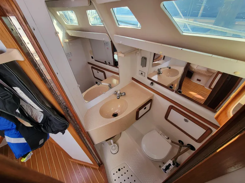 Slide: The Image of Bathroom interior of a 2003 Catalina 42 Mk2 yacht, featuring sink, toilet, and wooden accents. - 7