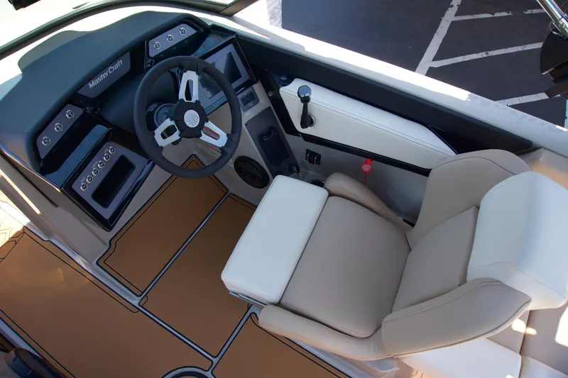 Slide: The Image of 2025 MasterCraft NXT22 boat interior with steering wheel and beige seating. - 10