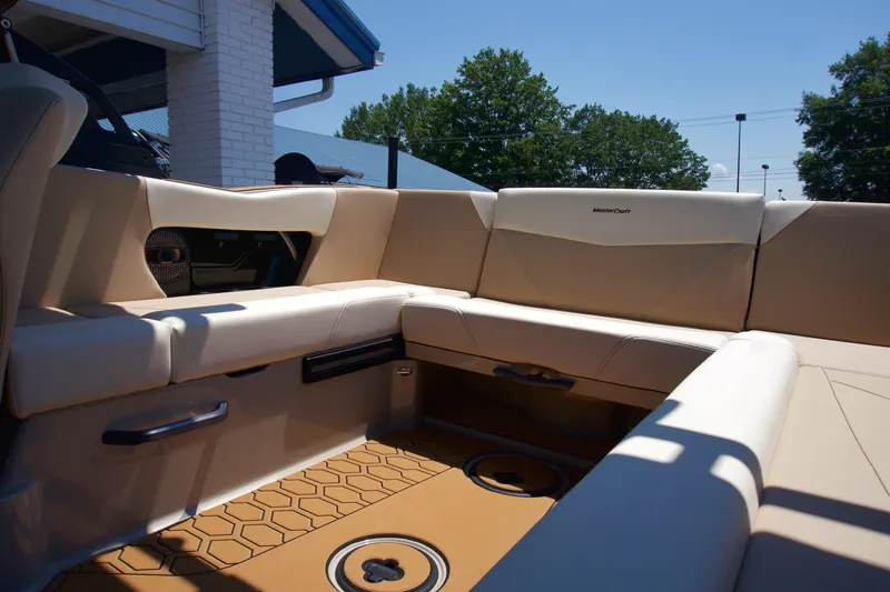 Slide: The Image of 2025 MasterCraft NXT22 boat interior with beige seating and hexagonal floor design. - 12