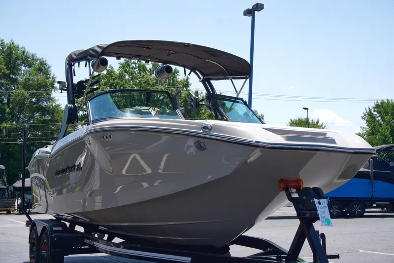 Slide: The Image of 2025 MasterCraft NXT22 boat on trailer, parked outdoors. - 4