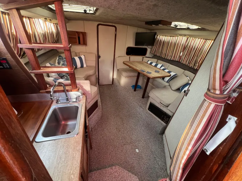 Slide: The Image of Interior of 1985 Bayliner 3250 Conquest boat with cozy seating and kitchenette. - 11