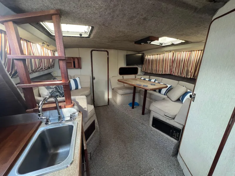 Slide: The Image of Interior of 1985 Bayliner 3250 Conquest boat with cozy seating and kitchenette. - 12