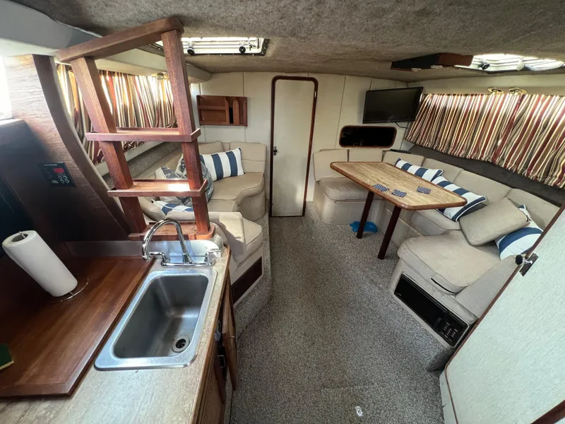 Slide: The Image of Interior of 1985 Bayliner 3250 Conquest boat with cozy seating and kitchenette. - 14