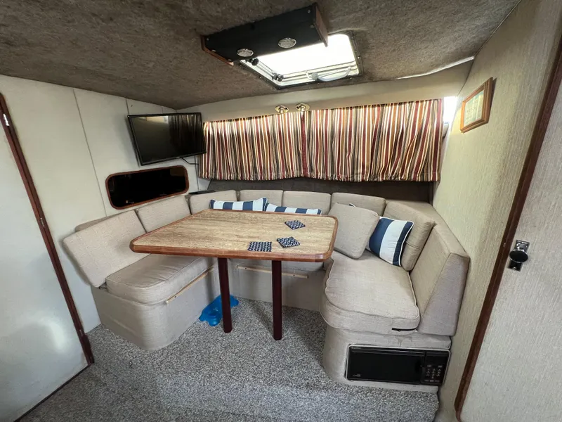 Slide: The Image of Interior of 1985 Bayliner 3250 Conquest with cozy seating and table. - 15