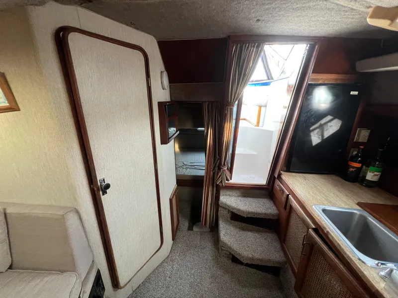 Slide: The Image of Interior of 1985 Bayliner 3250 Conquest boat with kitchenette and seating area. - 17