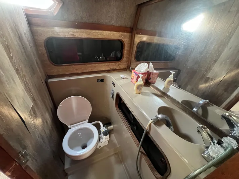 Slide: The Image of 1985 Bayliner 3250 Conquest boat bathroom with toilet and sink. - 21