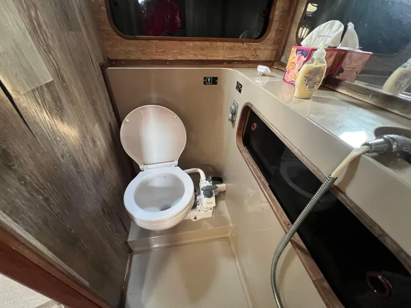 Slide: The Image of 1985 Bayliner 3250 Conquest boat bathroom with toilet and sink. - 22