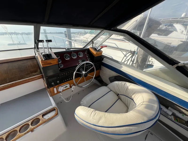 Slide: The Image of 1985 Bayliner 3250 Conquest boat interior with steering wheel and control panel. - 3