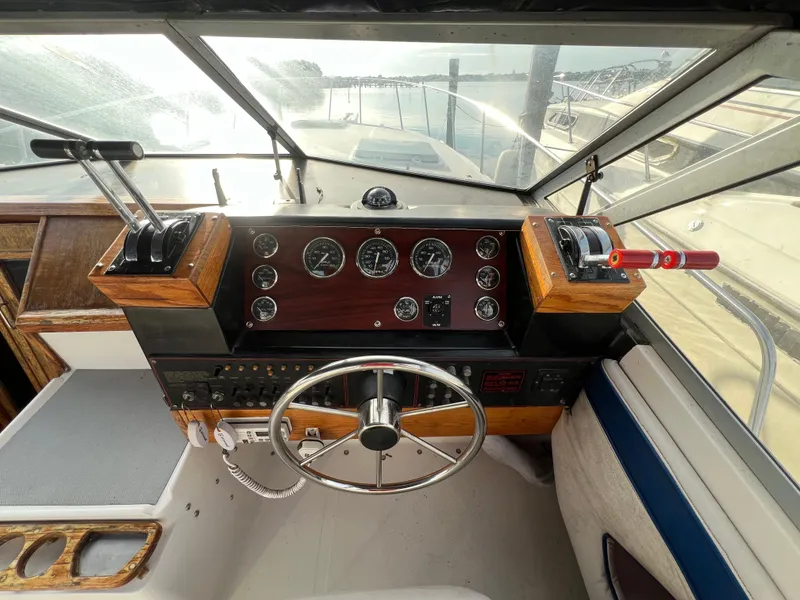Slide: The Image of 1985 Bayliner 3250 Conquest boat cockpit with steering wheel and control panel. - 4