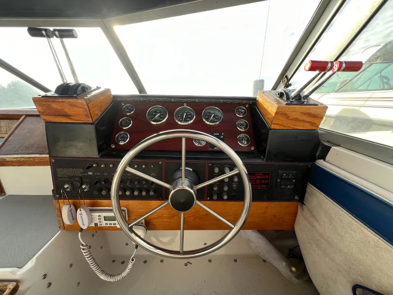 Slide: The Image of Helm of 1985 Bayliner 3250 Conquest with classic wooden dashboard and steering wheel. - 5