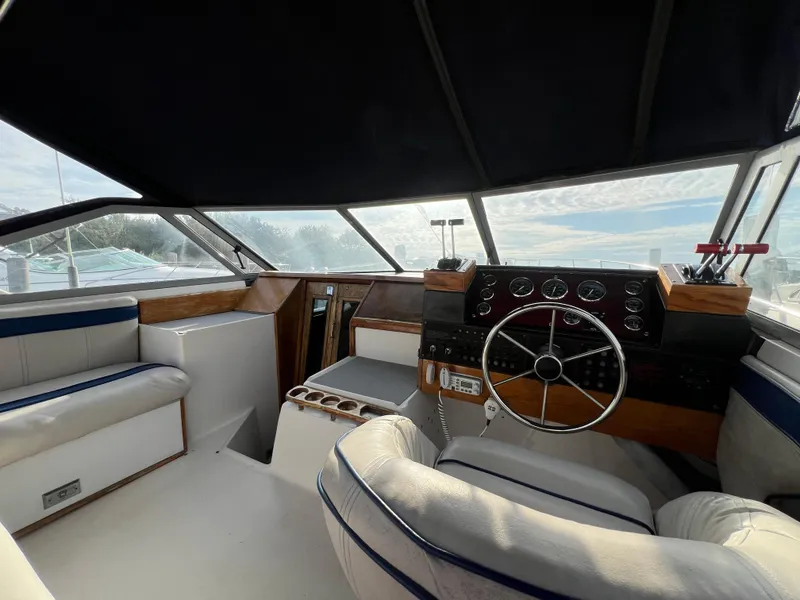 Slide: The Image of Interior of 1985 Bayliner 3250 Conquest boat with steering wheel and seating. - 7