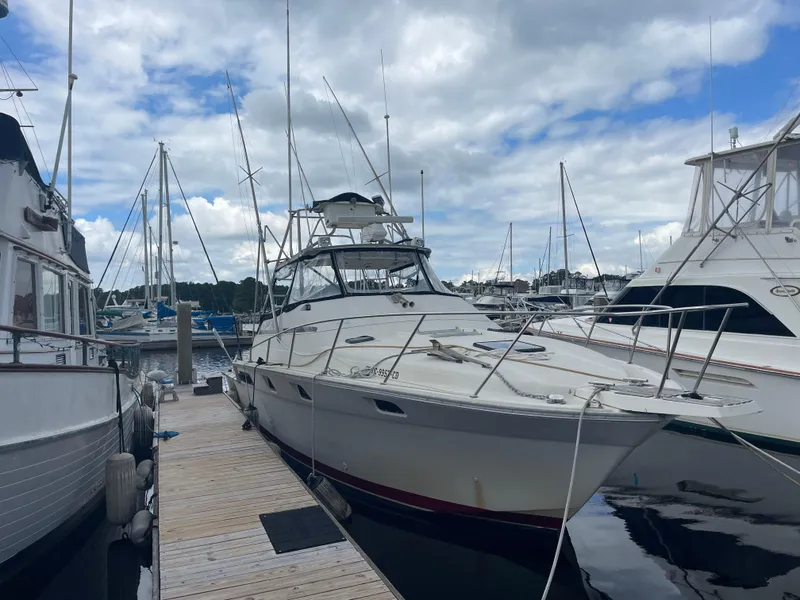The Image of 1983 Luhrs 340 boat docked at marina under cloudy sky. - 0
