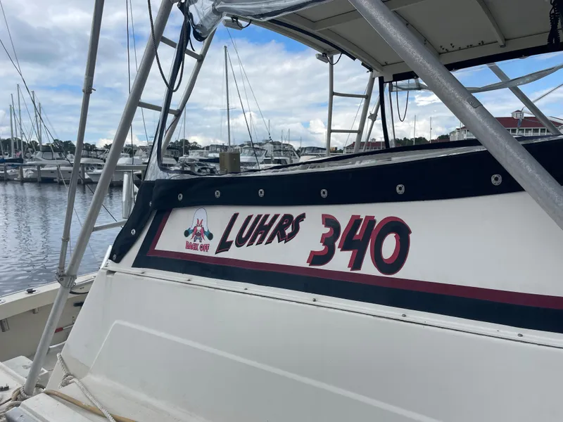 Slide: The Image of 1983 Luhrs 340 boat docked at marina, showcasing name and model. - 1