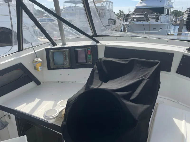Slide: The Image of 1983 Luhrs 340 boat cockpit with covered seat and navigation equipment at marina. - 10