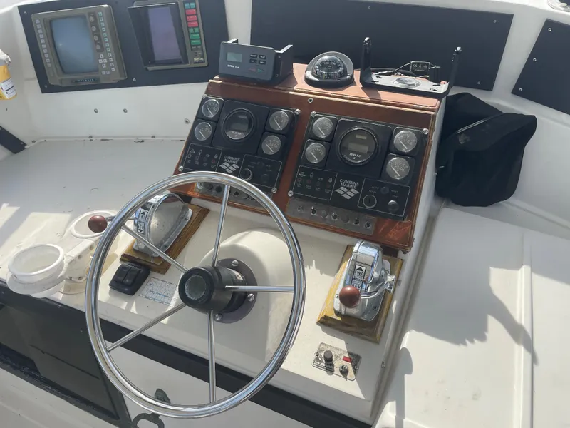Slide: The Image of 1983 Luhrs 340 boat dashboard with steering wheel and control panels. - 11