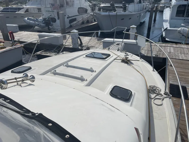 Slide: The Image of 1983 Luhrs 340 boat docked at marina, featuring deck and railing details. - 6