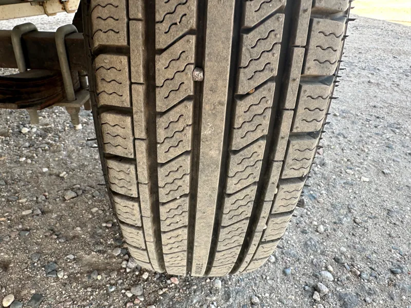 Slide: The Image of Close-up of a Larson 174 SEI 1995 tire on gravel surface, showing tread pattern. - 11