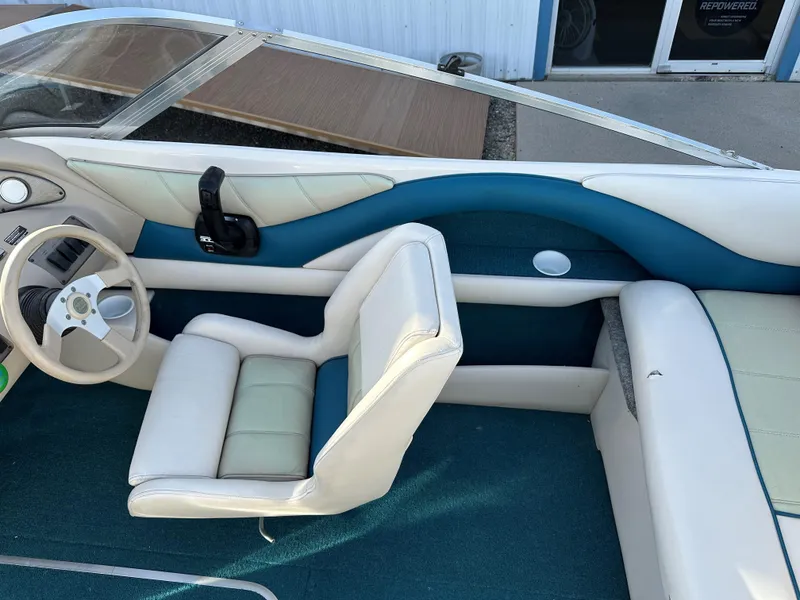 Slide: The Image of 1995 Larson 174 SEI boat interior with white and blue seating and steering wheel. - 7