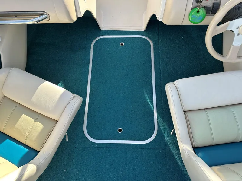 Slide: The Image of Interior of a 1995 Larson 174 SEI boat with teal carpet and beige seats. - 8