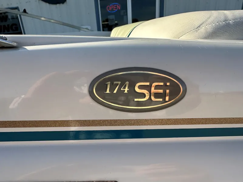 Slide: The Image of 1995 Larson 174 SEI boat emblem with gold and teal accents. - 9