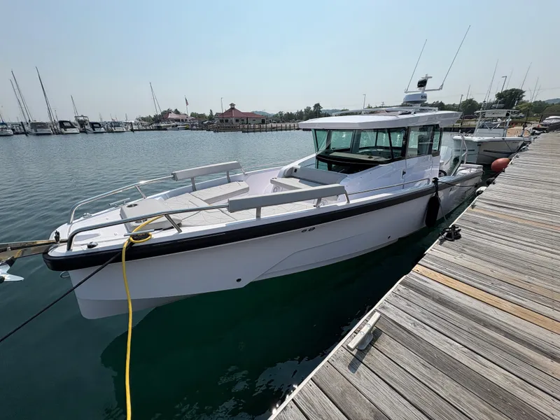 Slide: The Image of 2025 Axopar 29 XC Cross Cabin boat docked at a marina. - 0