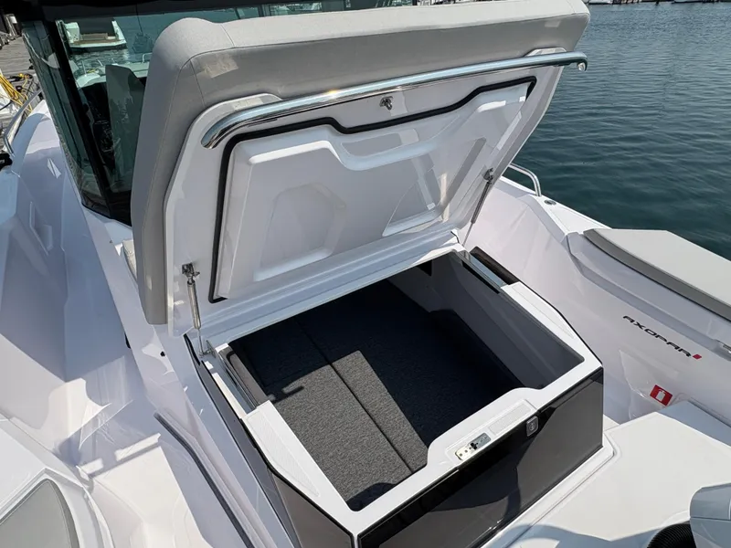 Slide: The Image of 2025 Axopar 29 XC Cross Cabin storage compartment open on a boat deck. - 10