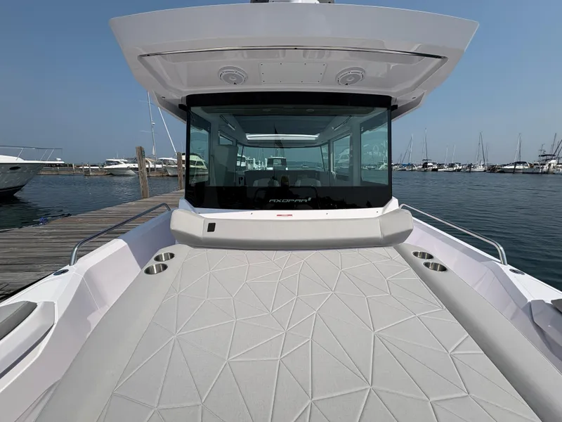 Slide: The Image of 2025 Axopar 29 XC Cross Cabin boat docked at marina, showcasing sleek design and spacious deck. - 13