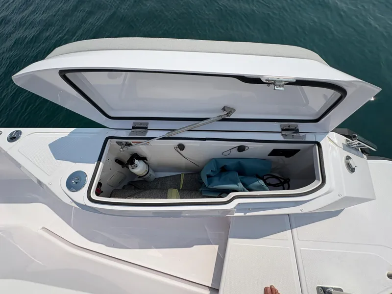 Slide: The Image of Open storage compartment on 2025 Axopar 29 XC Cross Cabin boat, showing interior details. - 14
