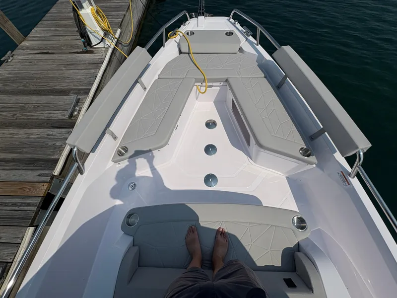 Slide: The Image of 2025 Axopar 29 XC Cross Cabin boat interior with gray seating and dock view. - 24