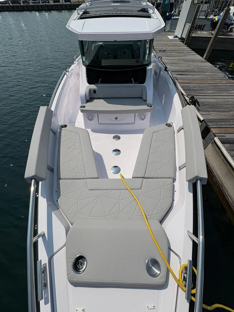 Slide: The Image of 2025 Axopar 29 XC Cross Cabin boat docked, featuring spacious seating and modern design. - 25