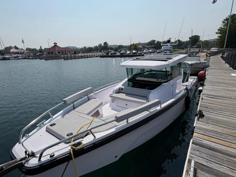 Slide: The Image of 2025 Axopar 29 XC Cross Cabin docked at a marina, showcasing sleek design and spacious deck. - 3