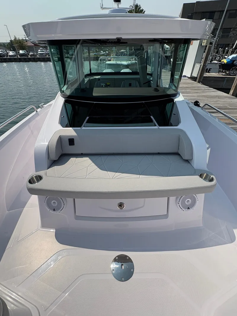 Slide: The Image of 2025 Axopar 29 XC Cross Cabin boat, docked, featuring sleek design and spacious seating. - 30