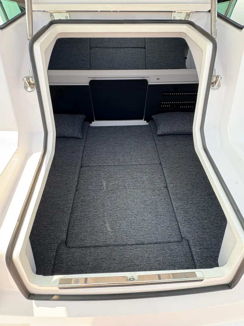 Slide: The Image of 2025 Axopar 29 XC Cross Cabin interior with gray cushioned sleeping area. - 31