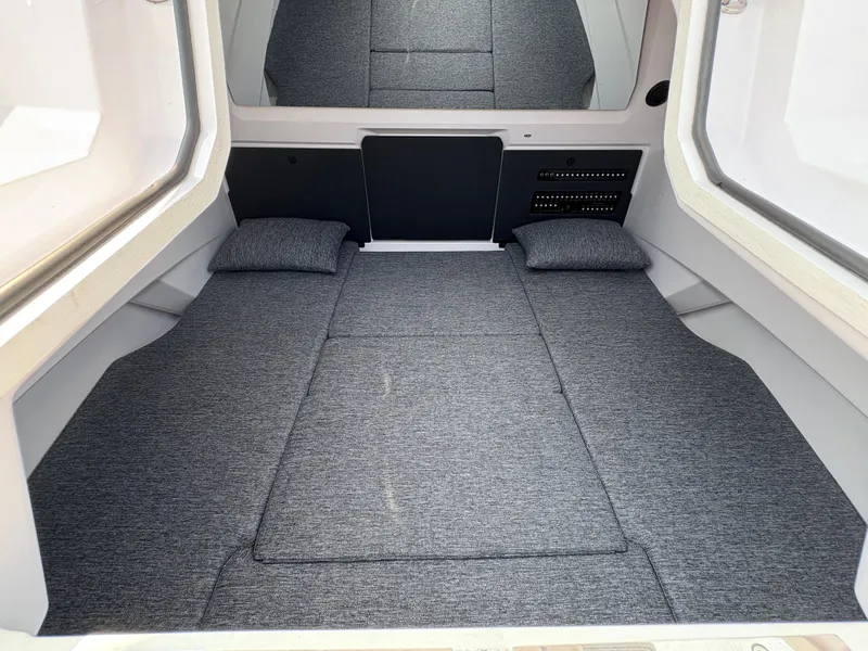 Slide: The Image of 2025 Axopar 29 XC Cross Cabin interior with gray bedding and cushions. - 32