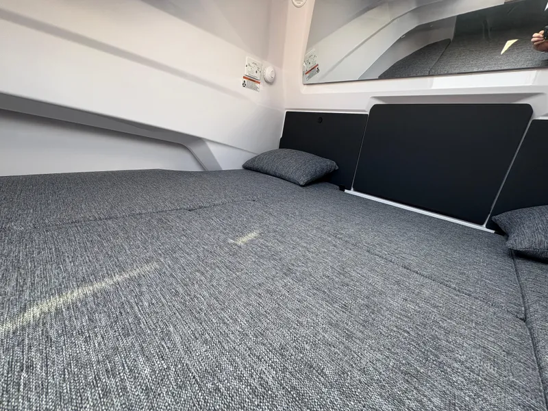 Slide: The Image of 2025 Axopar 29 XC Cross Cabin interior with gray bedding and modern design. - 34