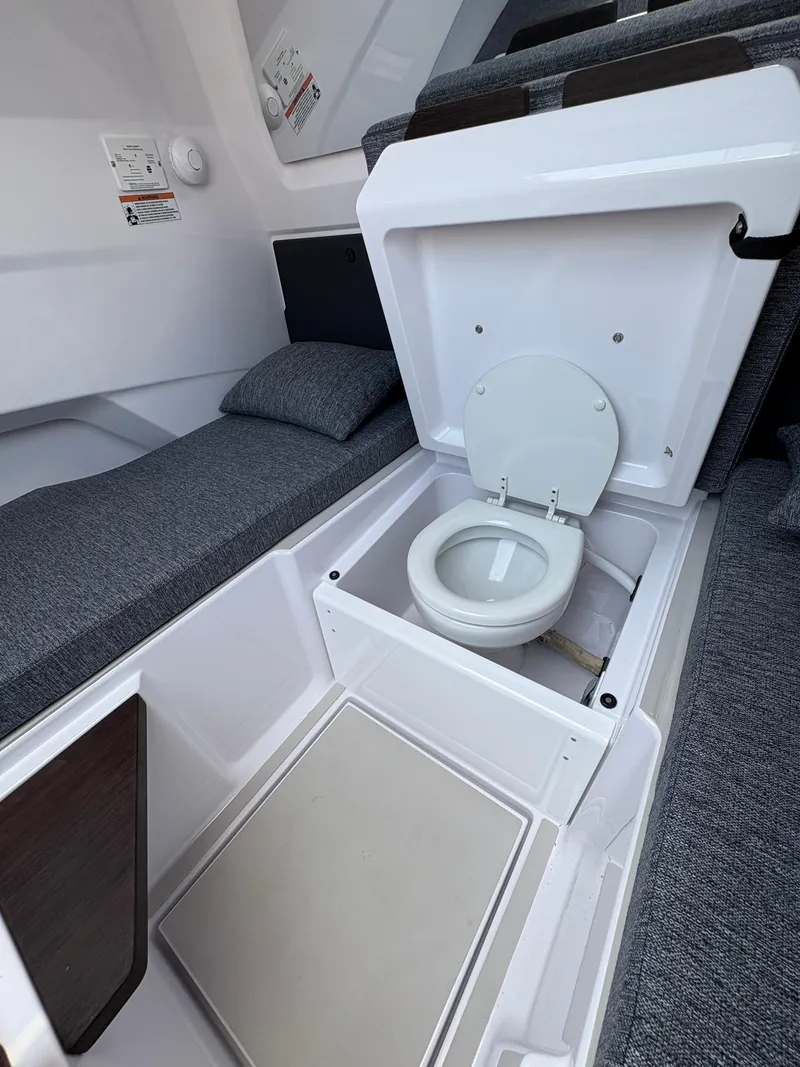 Slide: The Image of 2025 Axopar 29 XC Cross Cabin interior with hidden toilet and gray seating. - 35