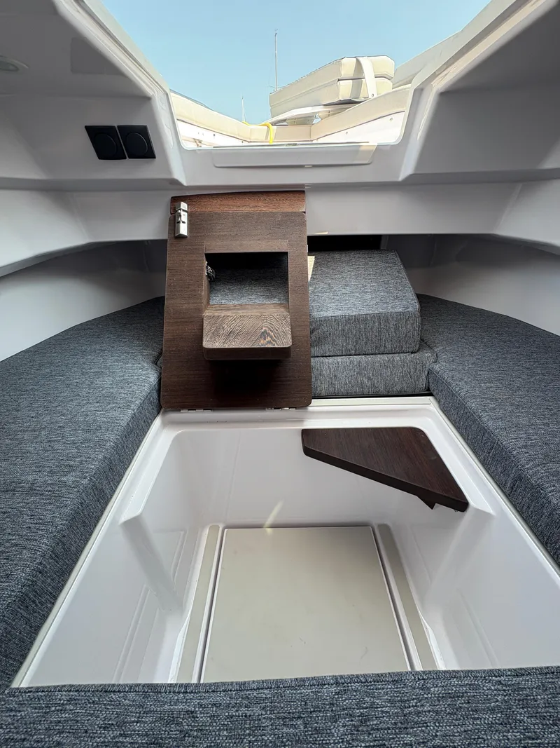 Slide: The Image of 2025 Axopar 29 XC Cross Cabin interior with gray seating and wooden accents. - 39