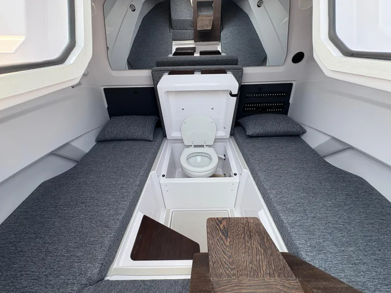 Slide: The Image of Interior of 2025 Axopar 29 XC Cross Cabin with compact toilet and seating area. - 41