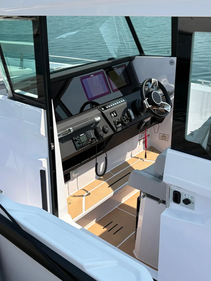 Slide: The Image of 2025 Axopar 29 XC Cross Cabin helm with modern controls and steering wheel. - 47