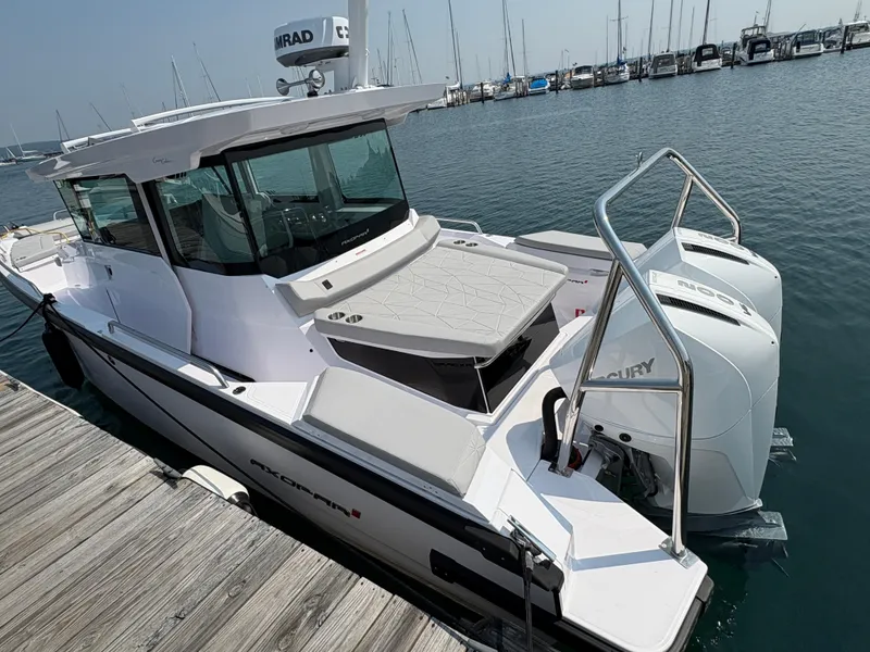 Slide: The Image of 2025 Axopar 29 XC Cross Cabin boat docked at marina with twin Mercury engines. - 5