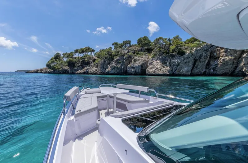 Slide: The Image of 2025 Axopar 29 Sun Top boat cruising near rocky coastline and clear blue water. - 10