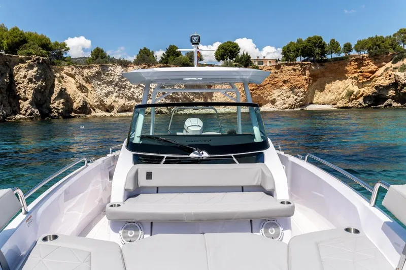 Slide: The Image of 2025 Axopar 29 Sun Top boat in scenic coastal waters, featuring sleek design and comfortable seating. - 14