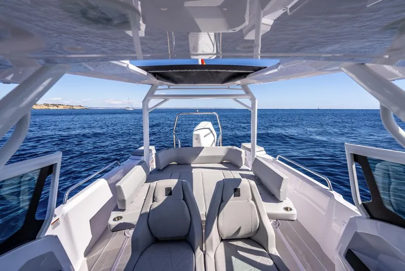 Slide: The Image of 2025 Axopar 29 Sun Top boat interior with ocean view, featuring sleek seating and modern design. - 16