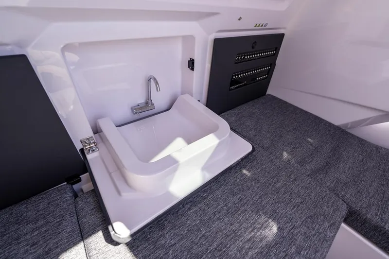 Slide: The Image of 2025 Axopar 29 Sun Top interior with compact sink and modern design. - 26