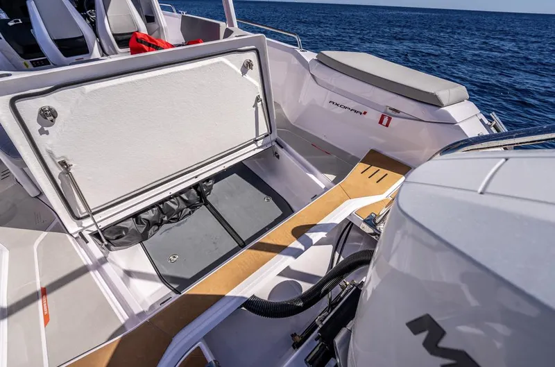 Slide: The Image of 2025 Axopar 29 Sun Top boat interior with open storage compartment, ocean view. - 27