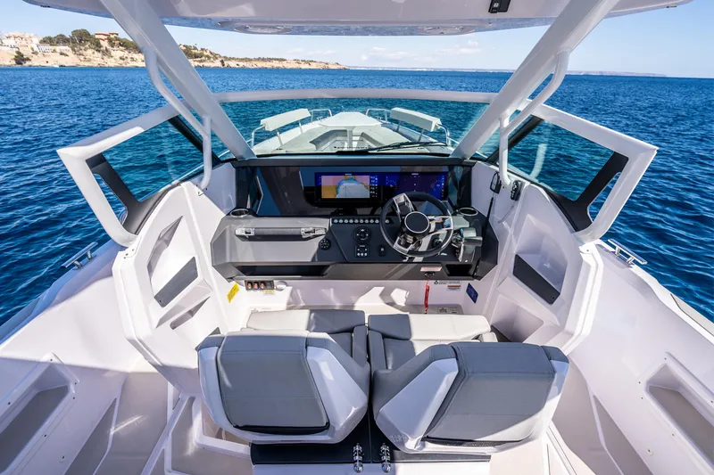 Slide: The Image of 2025 Axopar 29 Sun Top boat interior with modern dashboard and ocean view. - 4