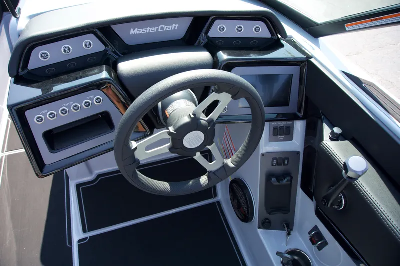 Slide: The Image of 2025 MasterCraft NXT24 boat dashboard with steering wheel and control panel. - 14