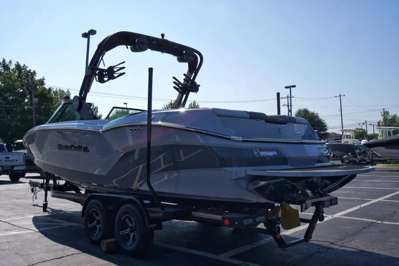 Slide: The Image of 2025 MasterCraft NXT24 boat on trailer in parking lot, side view. - 4