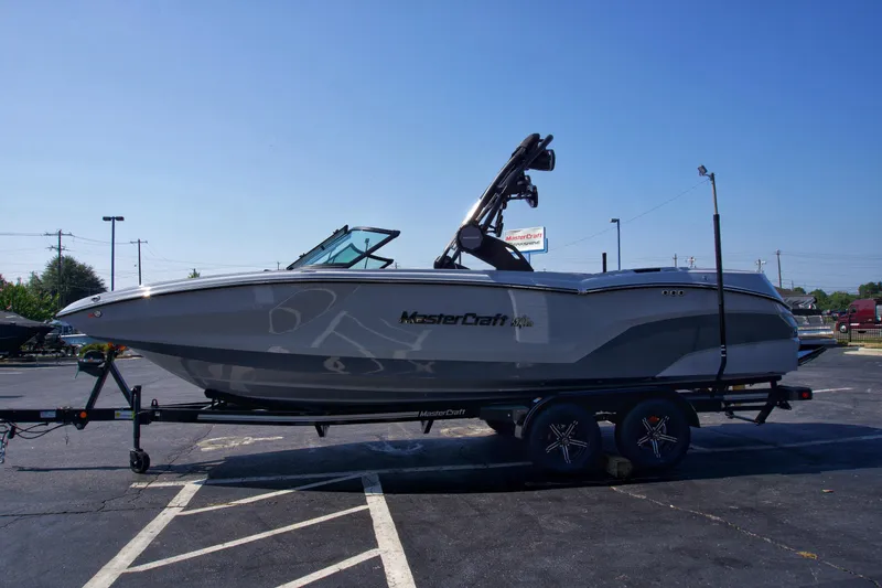 Slide: The Image of 2025 MasterCraft NXT24 boat on trailer in parking lot, side view. - 5