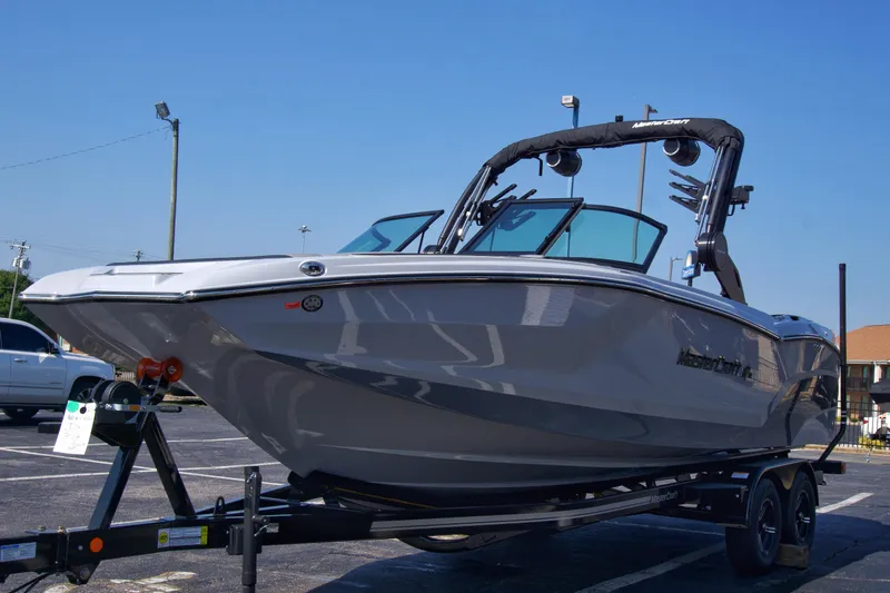 Slide: The Image of 2025 MasterCraft NXT24 boat on trailer, sleek design, parked outdoors. - 6
